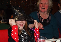 En glad heks med bestemor i bakgrunnen.  Foto/govvat: Lena Kristiansen